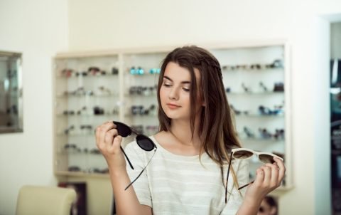 young-woman-shopping-holding-two-pairs-stylish-sunglasses_176420-3473