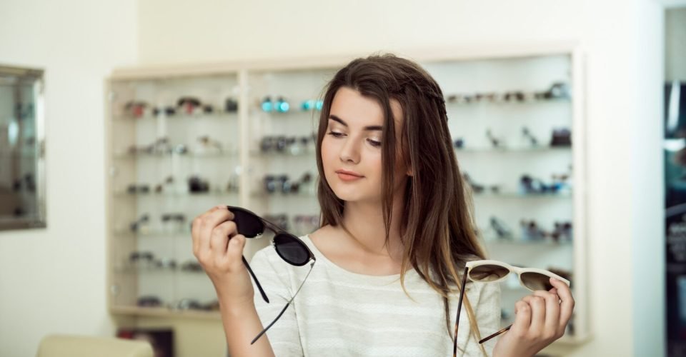 young-woman-shopping-holding-two-pairs-stylish-sunglasses_176420-3473